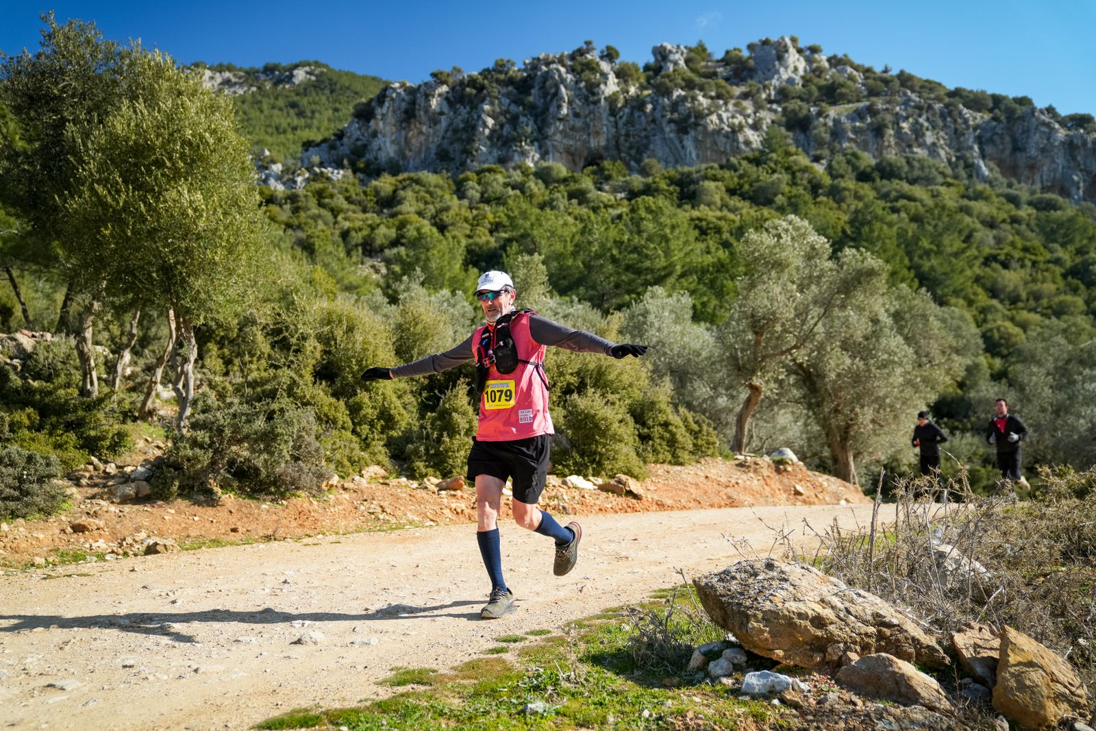 Coureur sur un sentier de montagne, pied se posant sous le bassin et genou fléchi