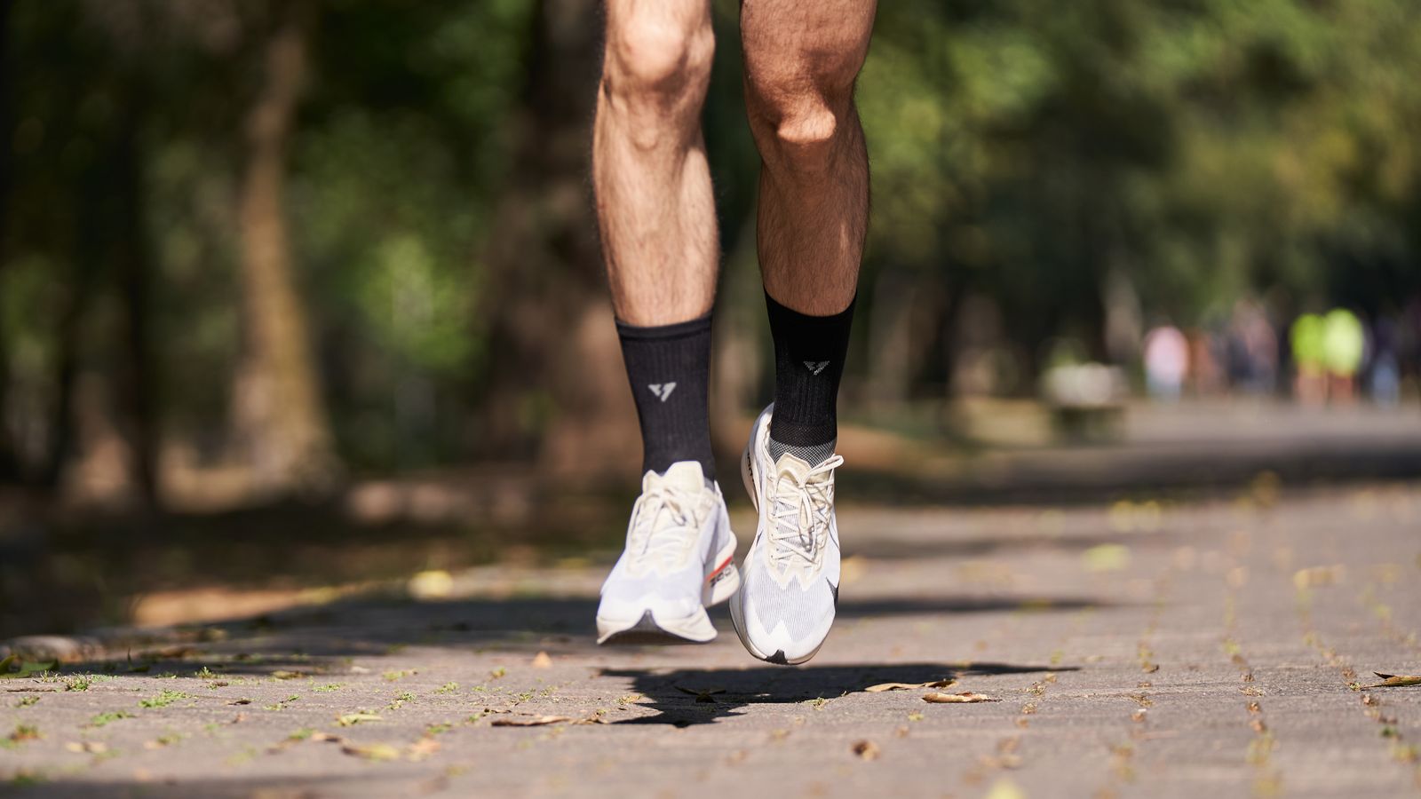 Gros plan sur les pieds d'un coureur pendant la phase de suspension, juste avant la pose au sol