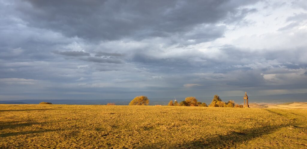 Le rebord du plateau de Gergovie éclairé par le soleil couchant, au-dessus de la plaine de la Limagne.