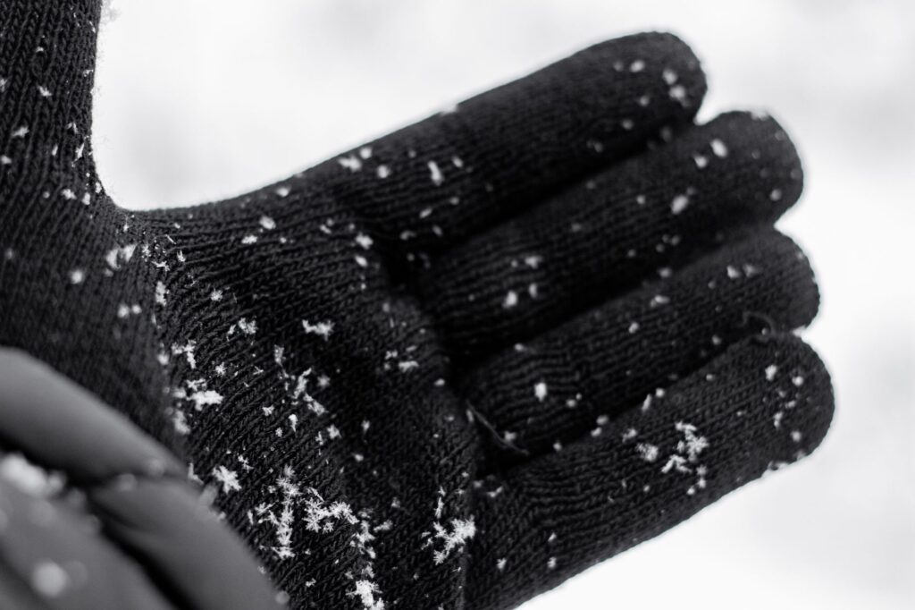 Gant d'hiver noir recueillant des flocons de neige