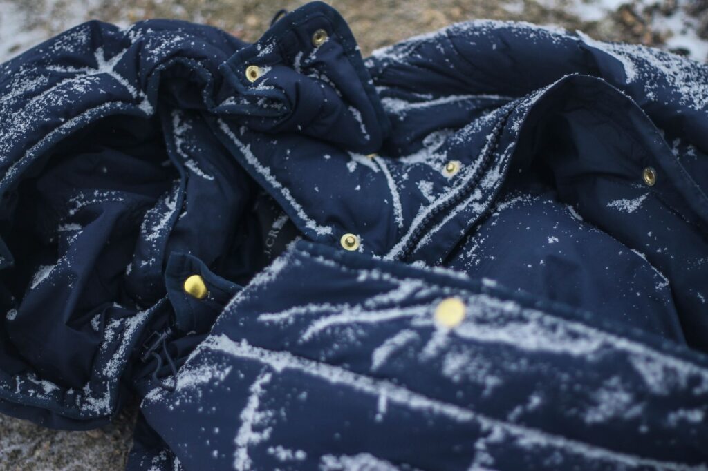 Flocons de neige posés à la surface du tissu bleu d'une veste d'hiver, avant absorption.